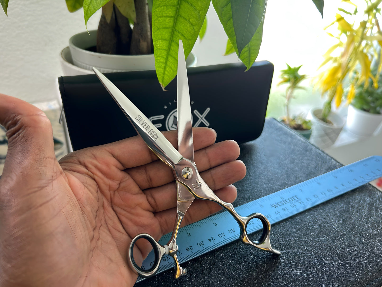 Scissors held in palm of hand.