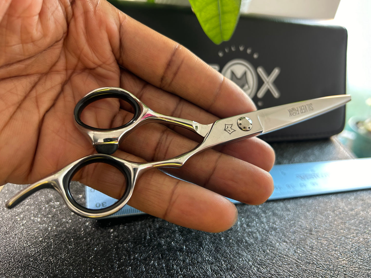 Scissors resting against palm of hand.