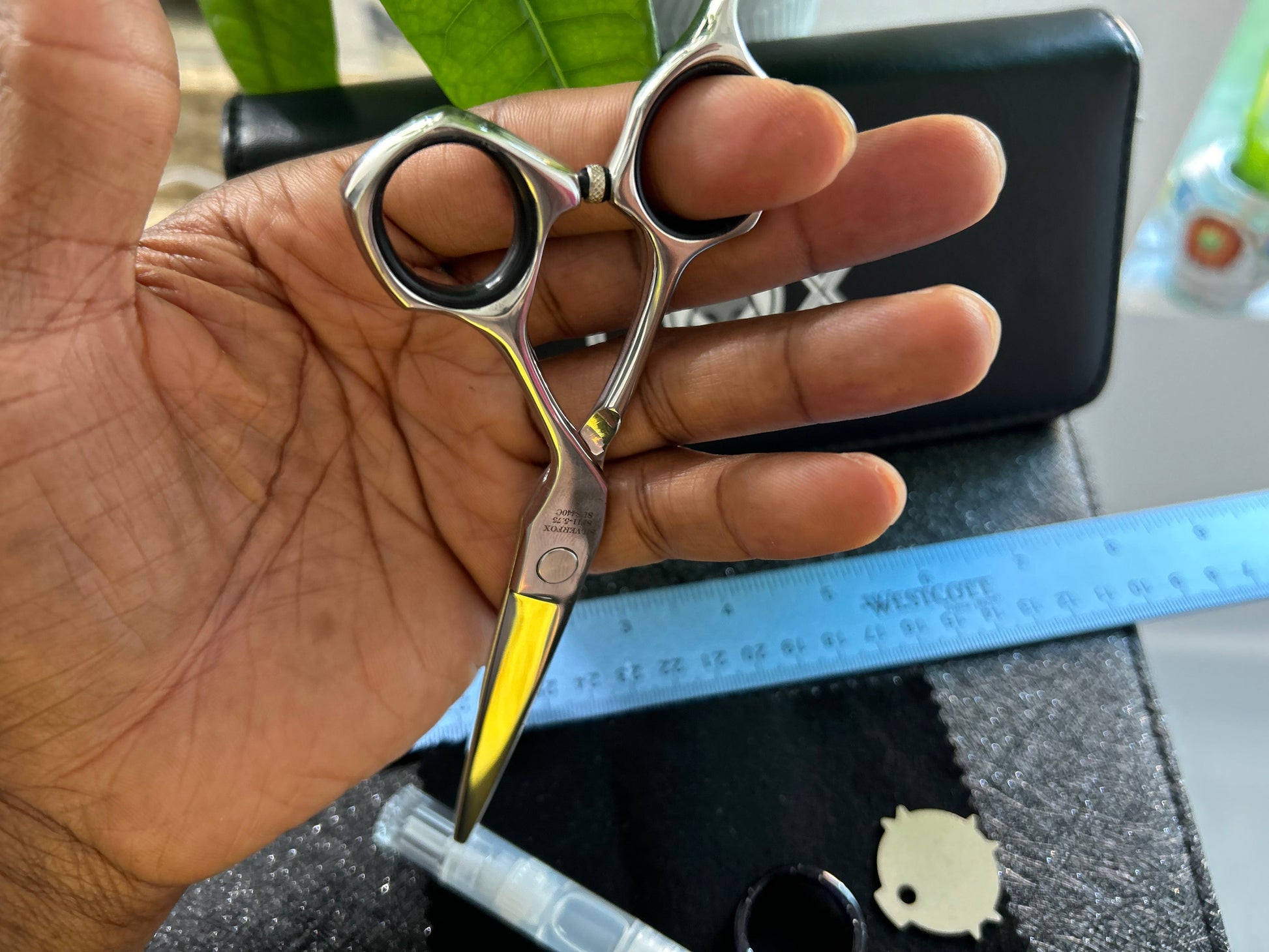 Scissors held with finger threaded through rings.