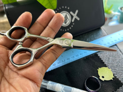 Scissors resting against palm of hand.