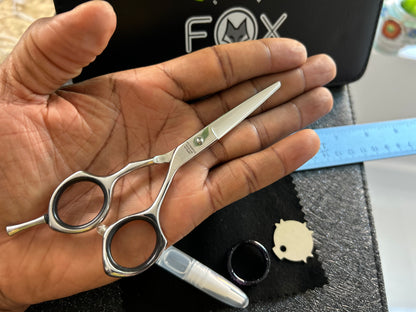 Scissors resting against palm of hand.