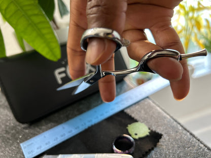 Scissors held with fingers threaded through rings.