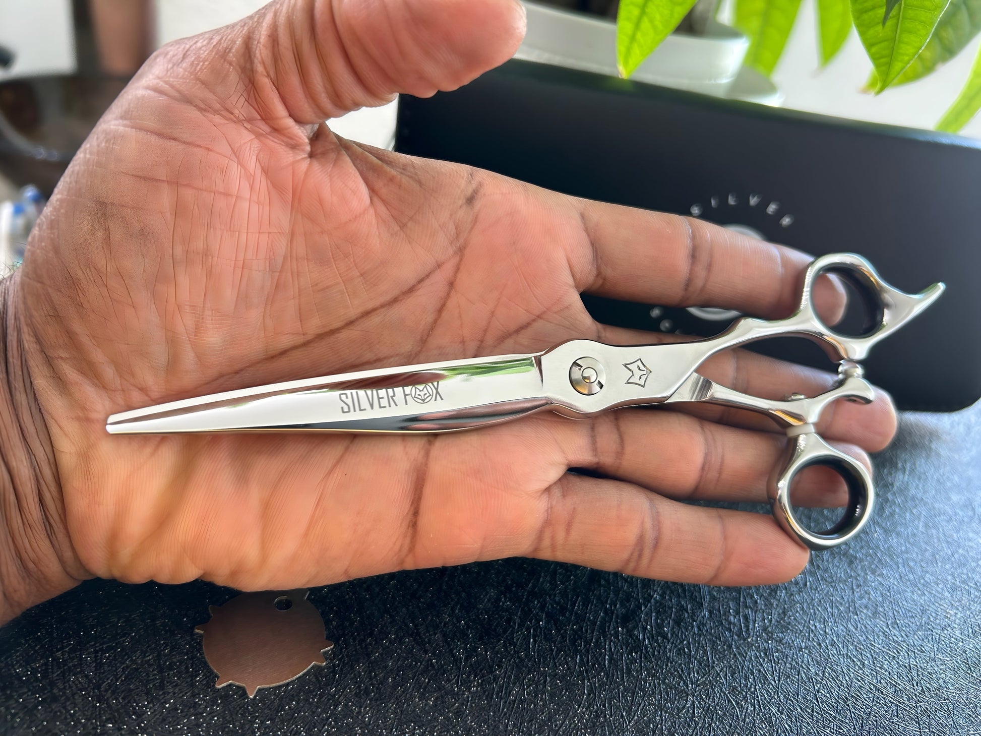 Scissors held in palm of hand.