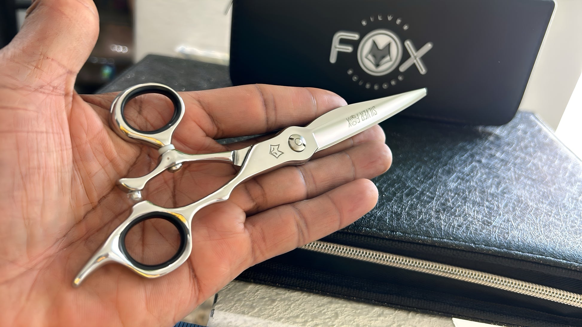 Scissors resting against palm of hand.