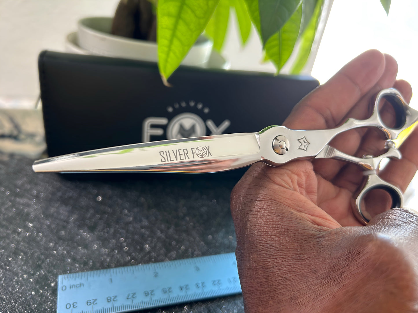 Scissors held in hand.