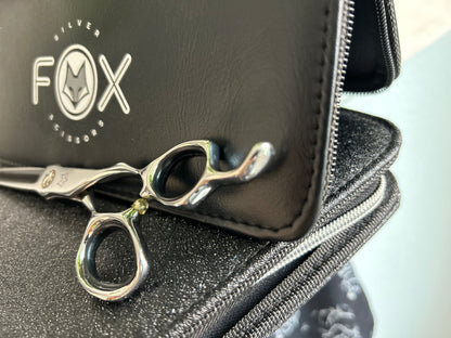 Scissors resting against black case.