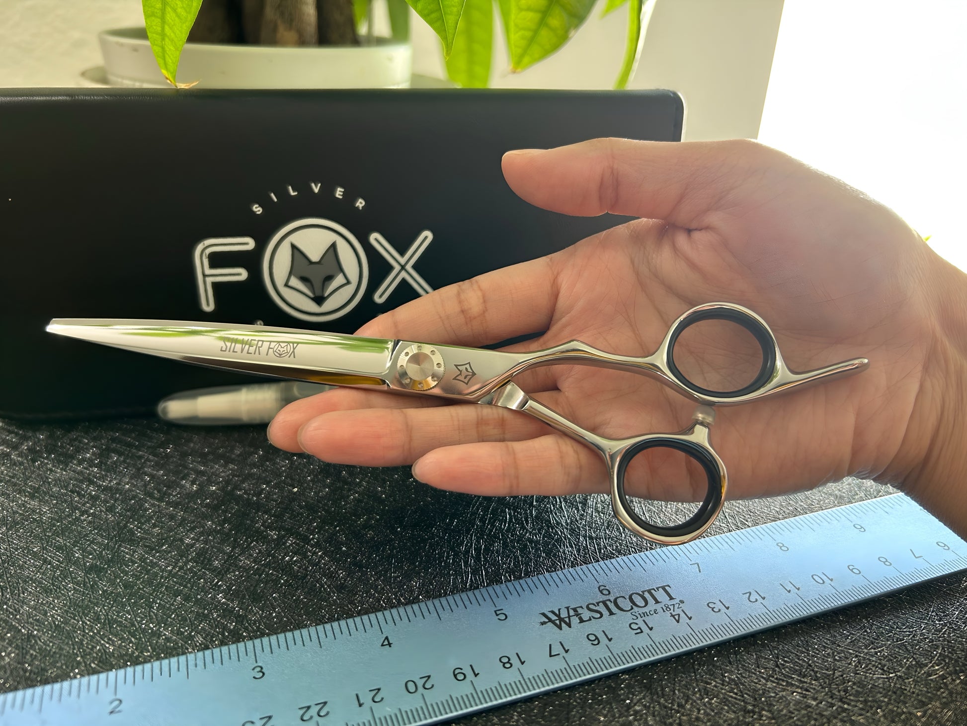 Scissors held in palm of hand.