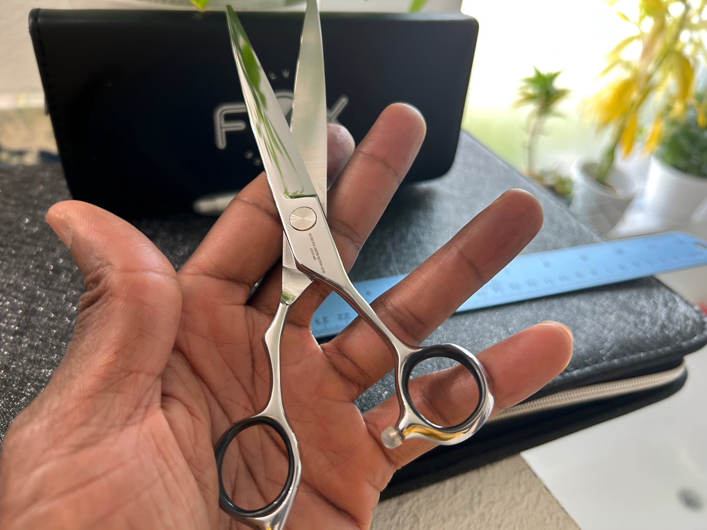 Scissors held in hand.