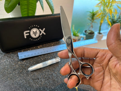 Scissors held with finger threaded through rings.