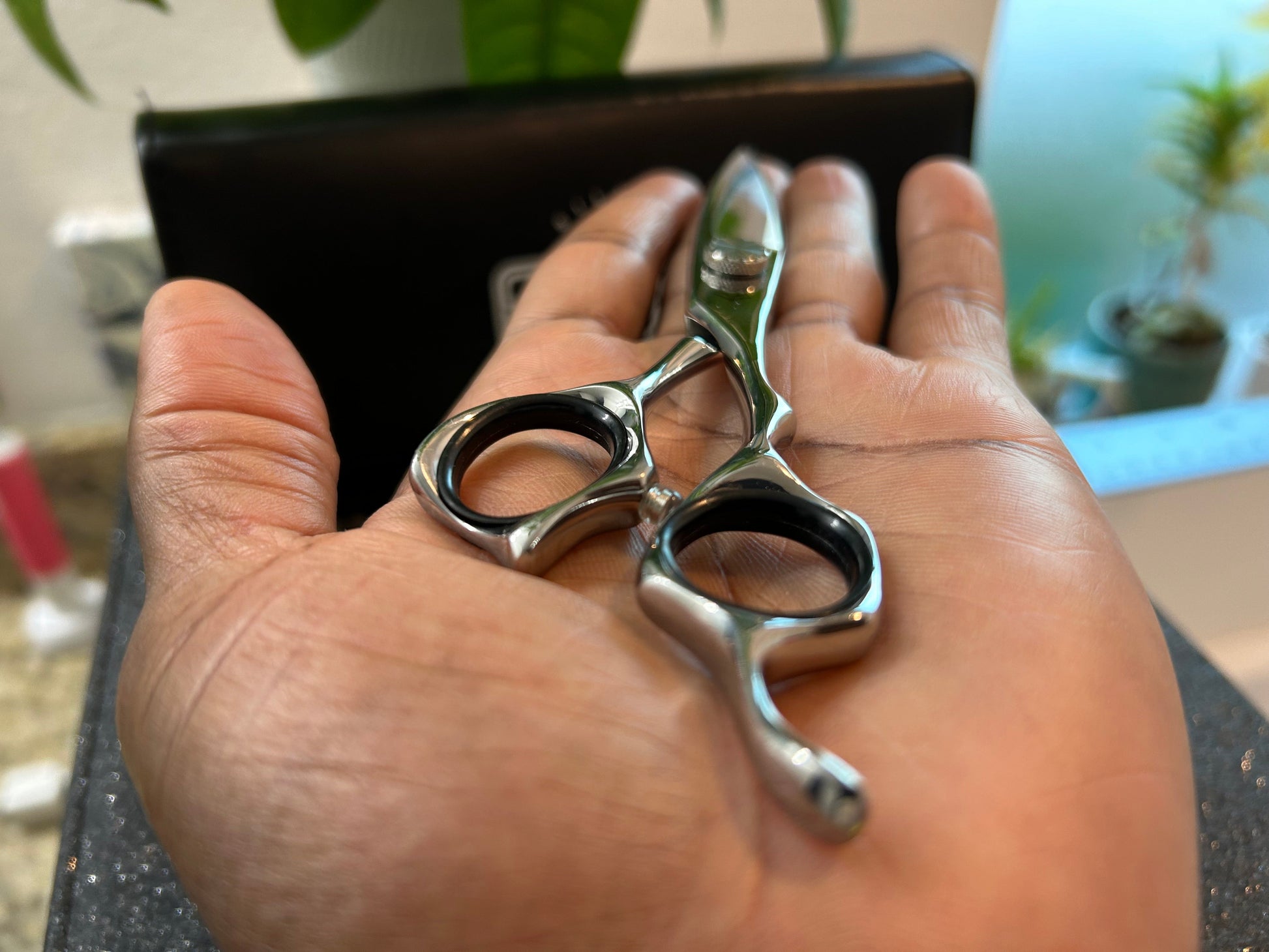 Scissors resting against palm of hand.