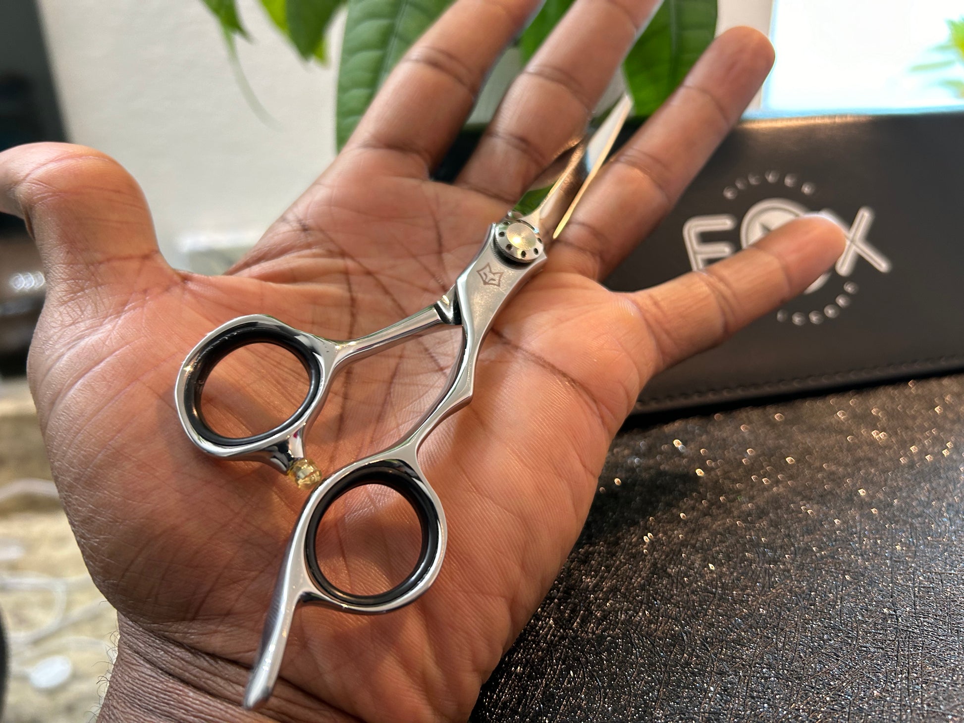 Scissors resting against palm of hand.