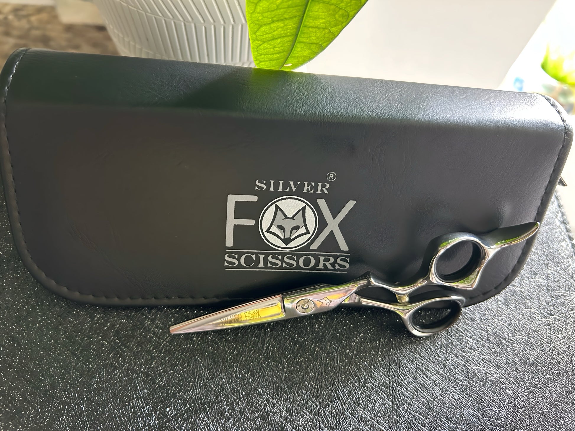 Top Down view of Silver Fox Scissors Model SF28 resting upright on display case.