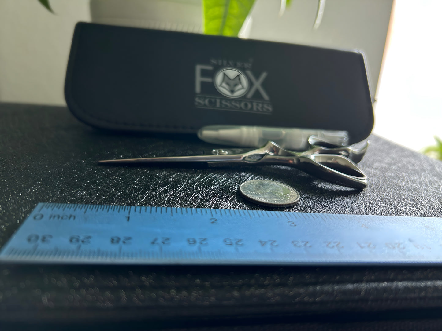 Frontal view of Silver Fox Scissors Model SF28 resting flat on display case, next to a ruler and coin.