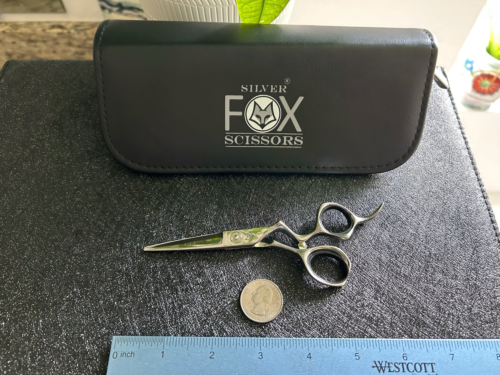 Top Down view of Silver Fox Scissors Model SF28 resting flat on display case, next to a ruler and coin.