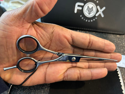 Scissors resting against palm of hand.