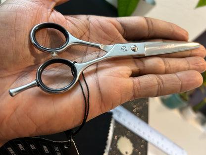 Scissors resting against palm of hand.