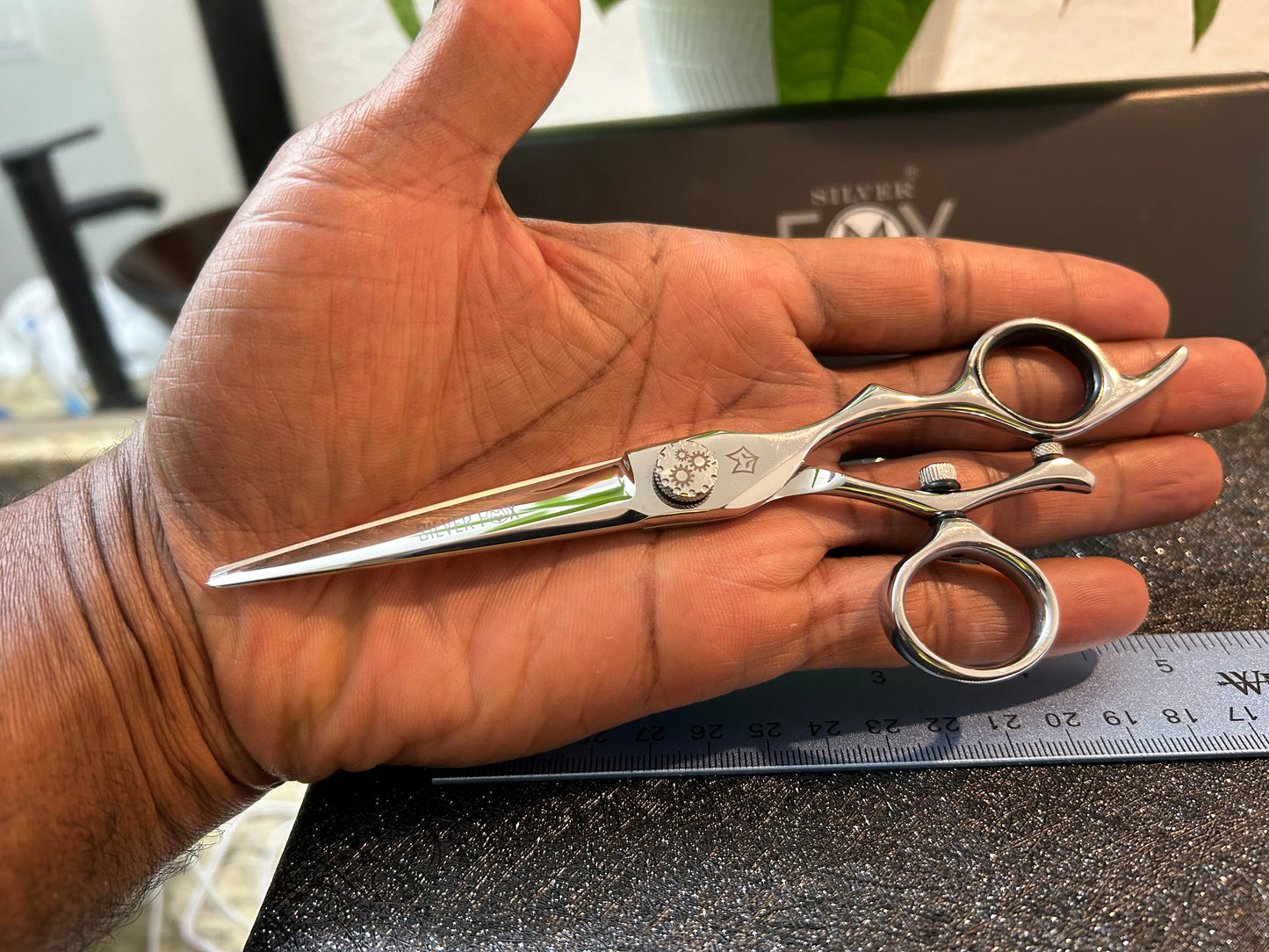 Scissors resting against palm of hand.