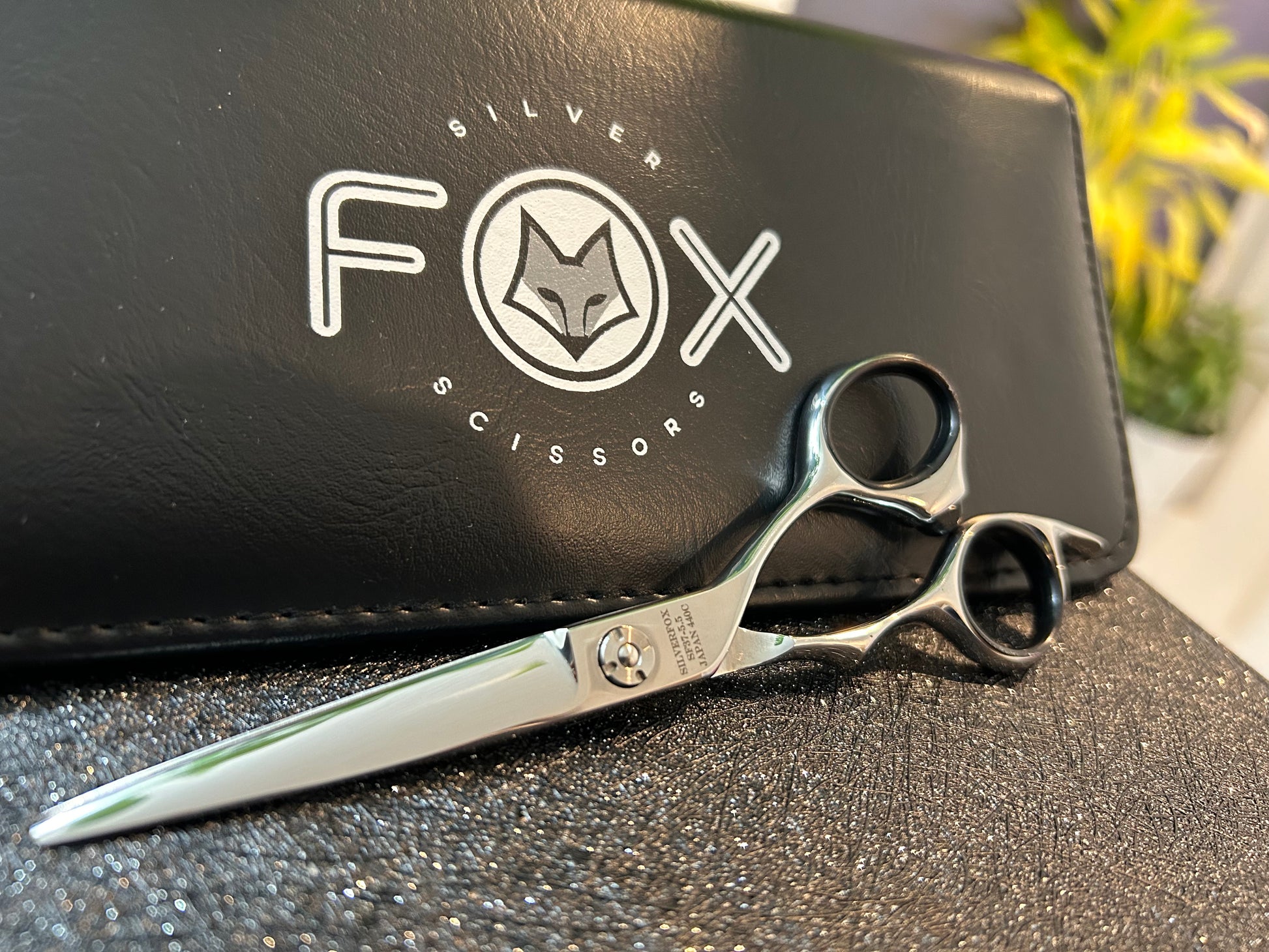 Scissors resting against black case.