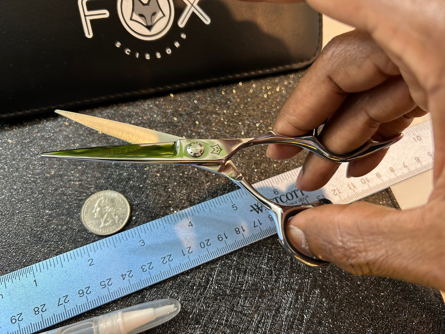 Scissors held open with fingers threaded through rings.