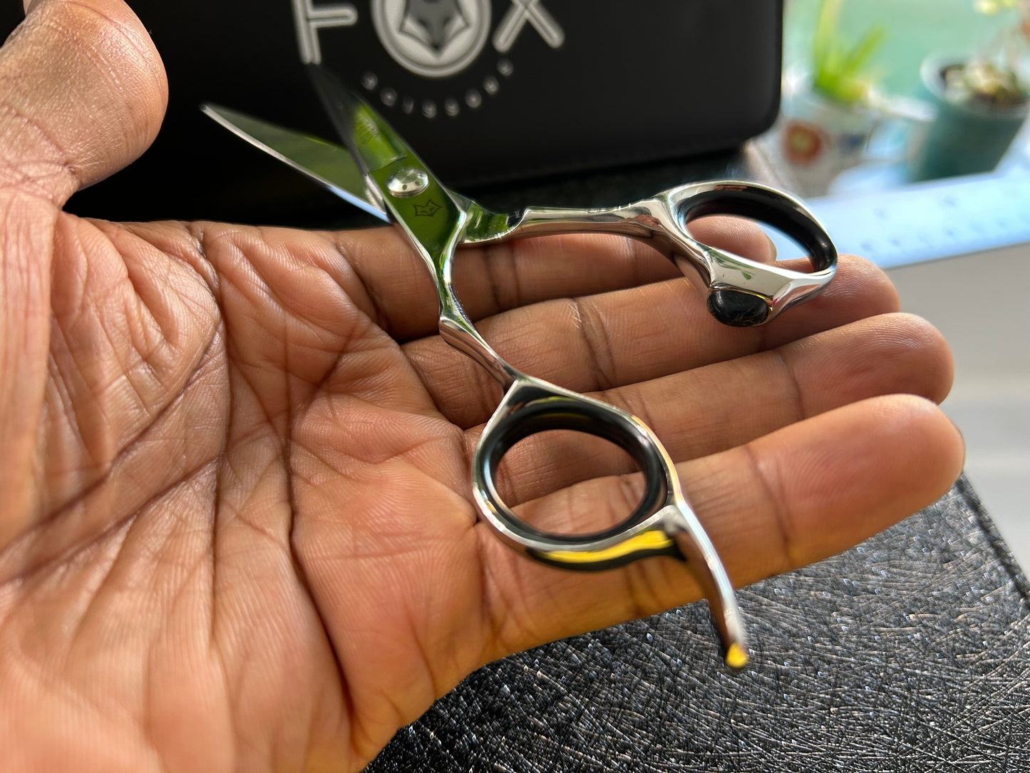 Scissors resting against palm of hand.