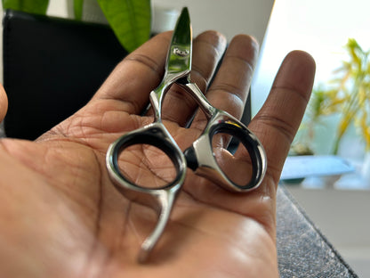 Scissors resting against palm of hand.