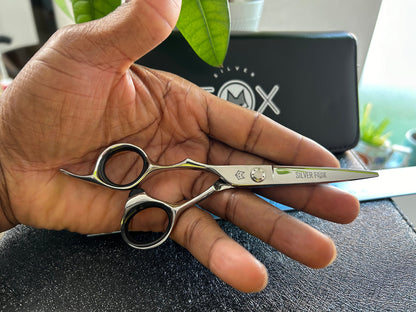 Scissors resting against palm of hand.