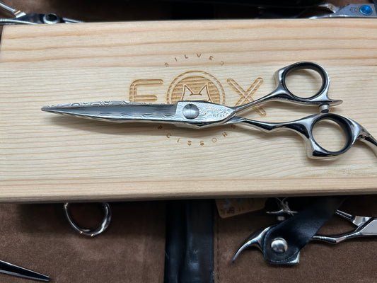 Scissors resting on top of the wooden case.