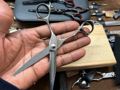 Scissors in cutting position, held in hand