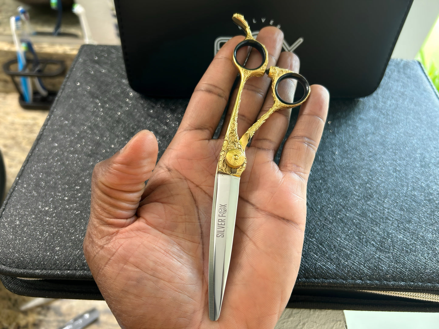 Scissors held in palm of hand.