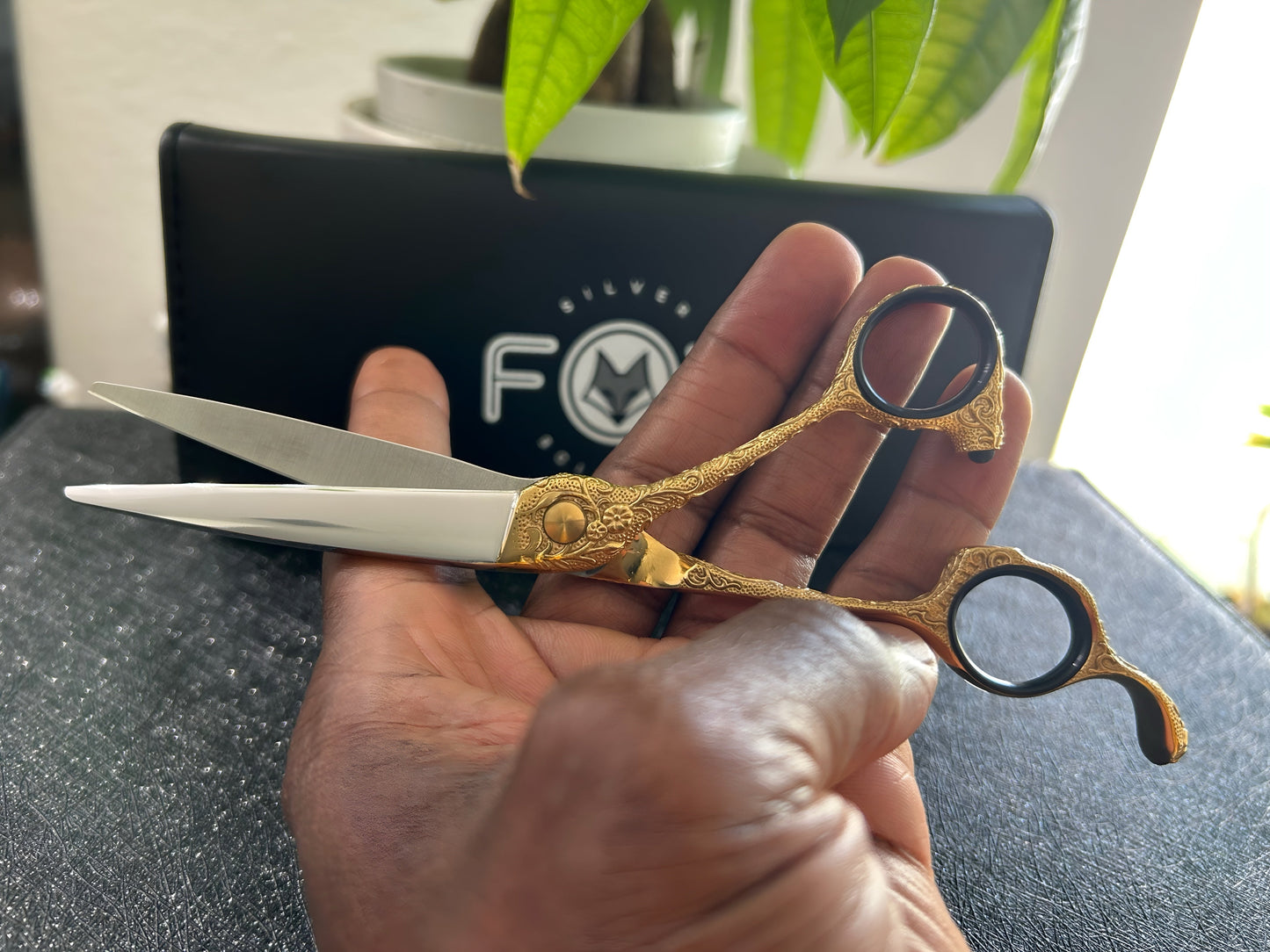 Scissors held in hand.